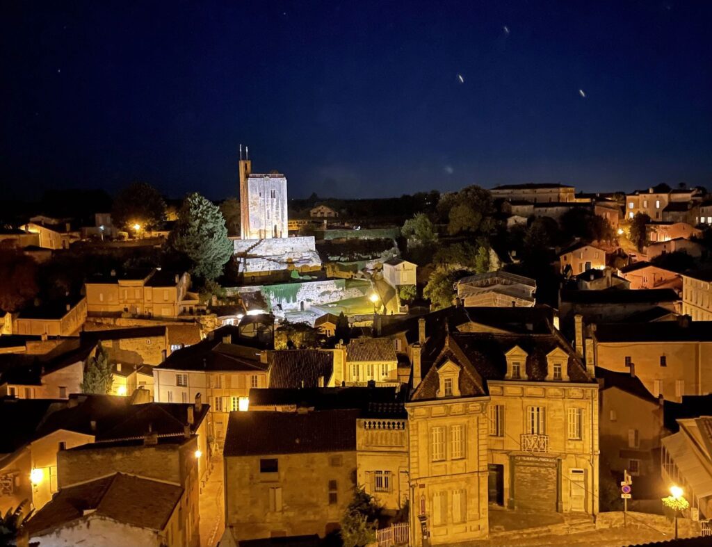 Night view of a historic town illuminated under a starry sky.