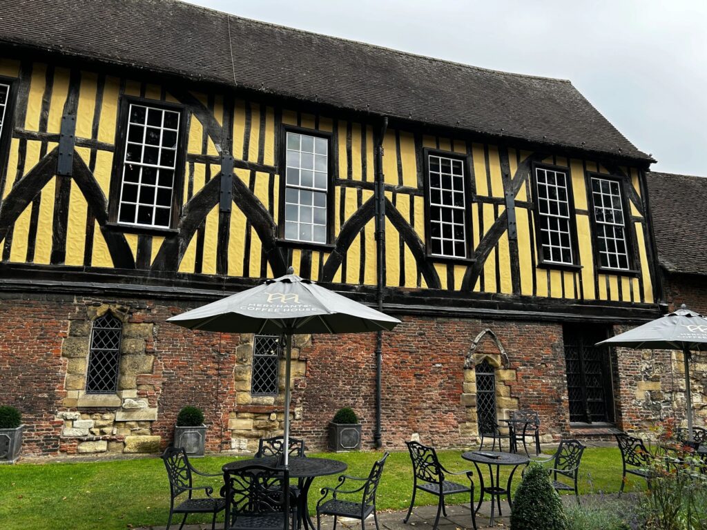 Historic half-timbered building with outdoor seating and umbrella.