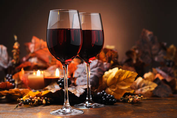 Two red wine glasses with autumn leaves