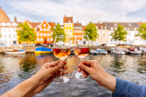 Hands toasting wine by colorful waterfront houses